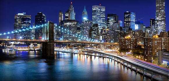 Night view of Brooklyn Bridge with illuminated New York City skyline in the background. - Olive Oil Times