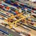 Aerial view of a cargo container terminal with various shipping containers and cranes. - Olive Oil Times