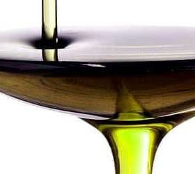 Olive oil being poured into a shallow bowl, showcasing its rich color and texture. - Olive Oil Times