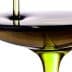 Olive oil being poured into a shallow bowl, showcasing its rich color and texture. - Olive Oil Times
