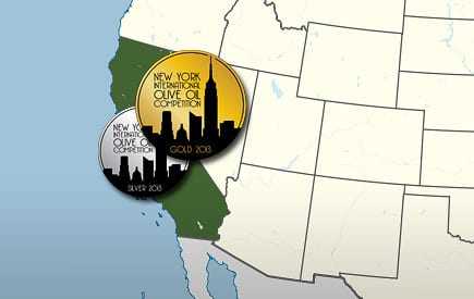 Two circular medals representing the New York International Olive Oil Competition with skyline designs. - Olive Oil Times