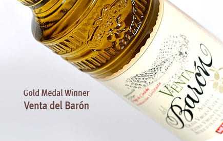 Gold medal winning olive oil bottle labeled Venta del Barón with ornate cap design. - Olive Oil Times