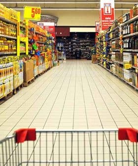 A grocery store aisle displaying various olive oil products on shelves. - Olive Oil Times