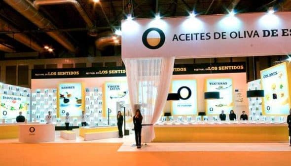 Exhibition booth for Spanish olive oils featuring displays and staff at an event. - Olive Oil Times
