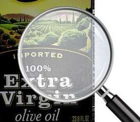 Bottle of extra virgin olive oil with a magnifying glass focusing on the label details. - Olive Oil Times