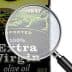 Bottle of extra virgin olive oil with a magnifying glass focusing on the label details. - Olive Oil Times