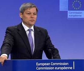 Man speaking at a podium during a European Commission press conference with a blue background. - Olive Oil Times