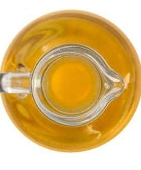 A glass cruet filled with yellow olive oil viewed from above. - Olive Oil Times