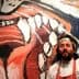 Chef with a beard and white chef's coat standing beside a large colorful mural of a lion's face. - Olive Oil Times