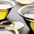 Several glass bowls containing olive oil, varying in size and filled with a golden liquid. - Olive Oil Times