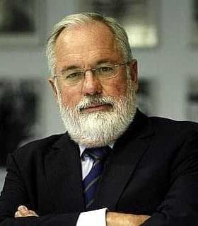 A man with a white beard wearing glasses and a suit, standing with arms crossed. - Olive Oil Times