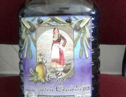 Plastic bottle of extra virgin olive oil with a label featuring a traditional Greek woman. - Olive Oil Times