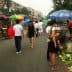 People shopping at a street market with various vegetables displayed on the ground. - Olive Oil Times