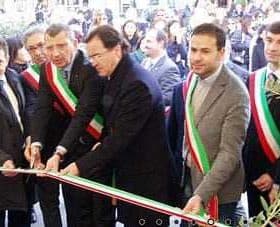 Group of officials participating in a ribbon cutting ceremony, wearing sashes and standing together. - Olive Oil Times