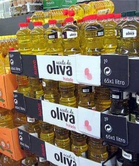 Shelves filled with various bottles of olive oil in a grocery store setting. - Olive Oil Times