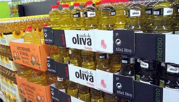 Shelves filled with various bottles of olive oil in a grocery store setting. - Olive Oil Times