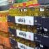 Shelves filled with various bottles of olive oil in a grocery store setting. - Olive Oil Times