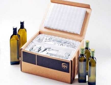 Open UPS shipping box containing wrapped olive oil bottles and packing materials. - Olive Oil Times