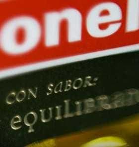 Close-up of a Carbonell olive oil label featuring text in Spanish about flavor and balance. - Olive Oil Times