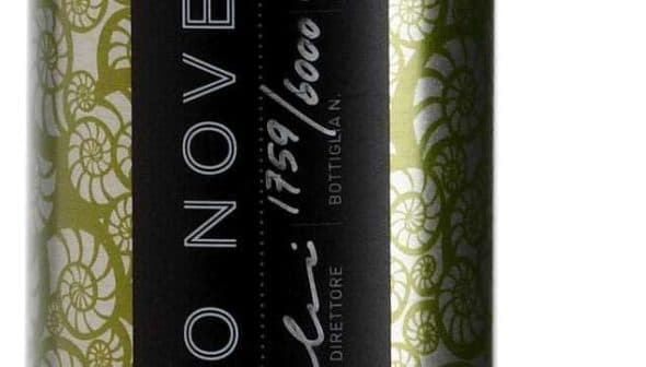 Green olive oil bottle featuring a decorative label with black and white design elements. - Olive Oil Times