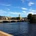 View of a bridge over water in Stockholm with buildings and trees in the background. - Olive Oil Times
