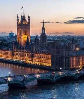 Houses of Parliament and Big Ben illuminated at sunset over the River Thames in London. - Olive Oil Times