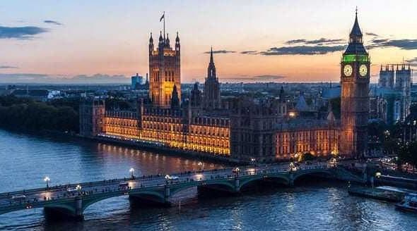 Houses of Parliament and Big Ben illuminated at sunset over the River Thames in London. - Olive Oil Times