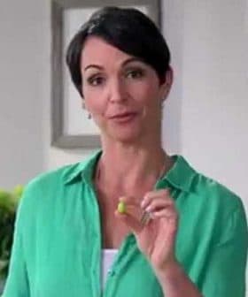 Woman with short dark hair holding a small green object in her hand while wearing a green shirt. - Olive Oil Times