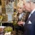 Charles and Camilla inspecting a bottle of olive oil at a market stall. - Olive Oil Times