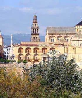 Historic buildings in Cordoba, featuring intricate architecture and a prominent bell tower. - Olive Oil Times