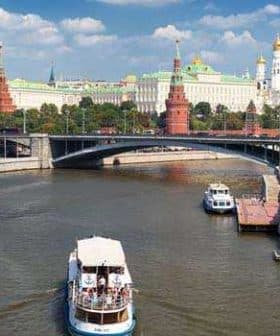 View of the Moscow River with a boat and historical buildings in the background, including the Kremlin. - Olive Oil Times
