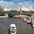 View of the Moscow River with a boat and historical buildings in the background, including the Kremlin. - Olive Oil Times