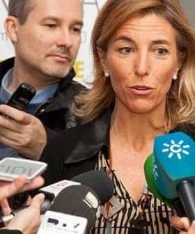 A woman speaking to reporters while multiple microphones are directed towards her. - Olive Oil Times