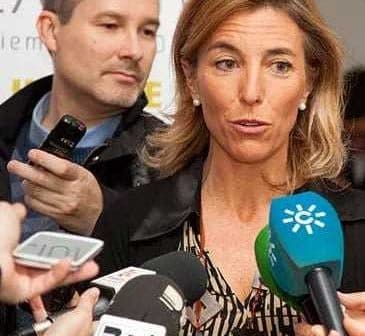 A woman speaking to reporters while multiple microphones are directed towards her. - Olive Oil Times