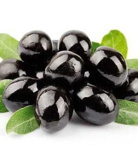 A cluster of black olives resting on green leaves, showcasing their glossy surface. - Olive Oil Times