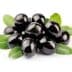 A cluster of black olives resting on green leaves, showcasing their glossy surface. - Olive Oil Times