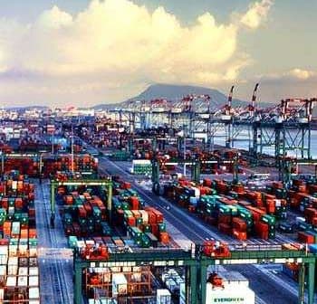 Aerial view of a busy container port filled with cargo containers and cranes. - Olive Oil Times