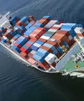 Cargo ship with multiple stacked shipping containers navigating through water. - Olive Oil Times