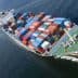 Cargo ship with multiple stacked shipping containers navigating through water. - Olive Oil Times