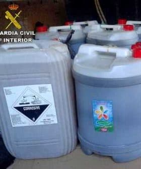 Several containers labeled as corrosive substance, stacked together with a warning symbol. - Olive Oil Times