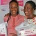 Two women smiling while holding Mother's Delivery Kits in their hands. - Olive Oil Times