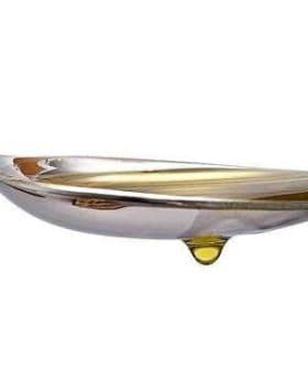 A silver spoon with a drop of olive oil resting at the tip of the spoon. - Olive Oil Times
