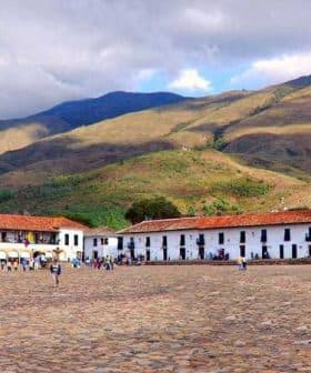 Colonial buildings with red roofs and cobblestone plaza in a mountainous region of Colombia. - Olive Oil Times