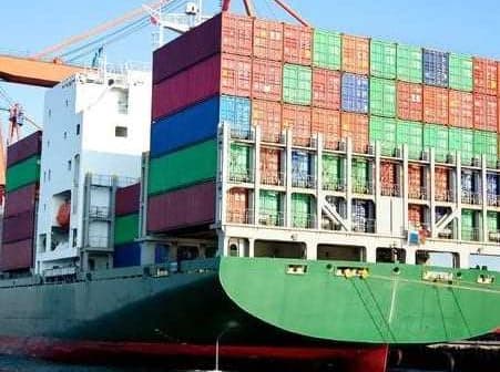 Large container ship loaded with colorful shipping containers at a dock. - Olive Oil Times