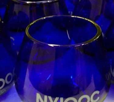 Set of cobalt blue glasses featuring the NYIOOC logo on the front. - Olive Oil Times