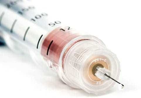 Close-up view of a syringe with a clear barrel and a fine needle at the tip. - Olive Oil Times