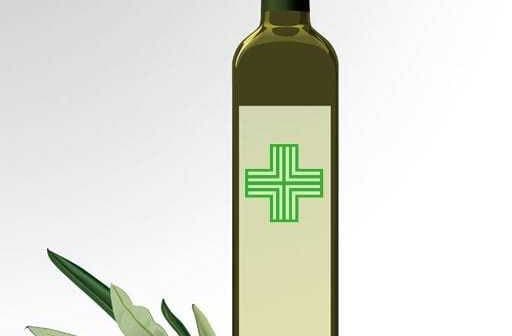 Olive oil bottle with a green cross symbol and olives beside it. - Olive Oil Times