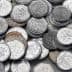 A collection of various Czech coins arranged in a disordered pile on a flat surface. - Olive Oil Times