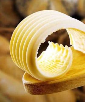 Slices of butter arranged on a wooden spoon with a smooth texture. - Olive Oil Times