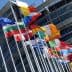 Various national flags of European countries displayed outside the European Parliament building. - Olive Oil Times